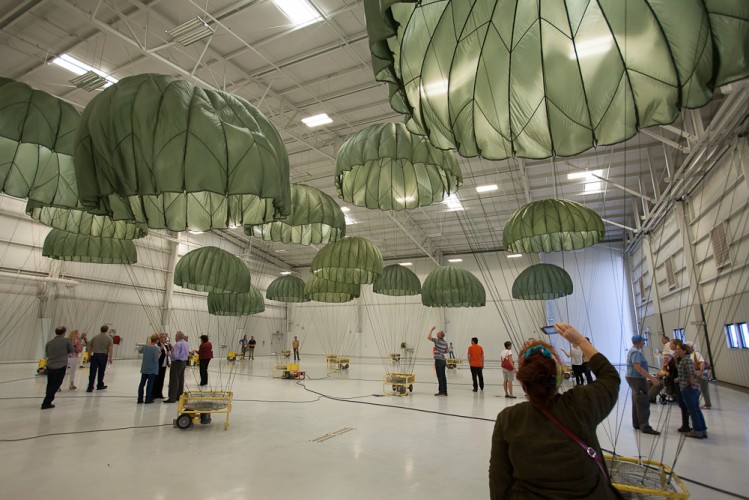 Héctor Zamora, installation view, OG-107 Scenery, 2012. U.S. Army-issue reserve parachute (model: T-10R MIRPS-SLCP, color: olive green-107 color, size: 24-foot diameter); electric fans; airplane hangar. Courtesy of the artist. © Héctor Zamora. Photo: Dan Vermillion