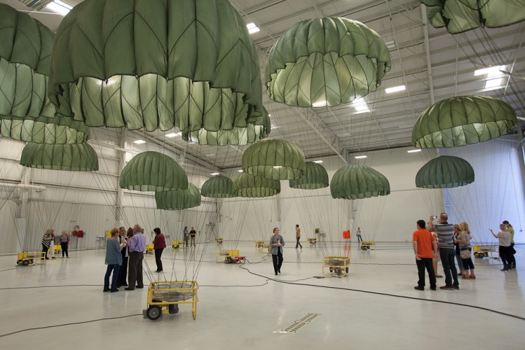 Héctor Zamora, installation view, OG-107 Scenery, 2012. U.S. Army-issue reserve parachute (model: T-10R MIRPS-SLCP, color: olive green-107 color, size: 24-foot diameter); electric fans; airplane hangar. Courtesy of the artist. © Héctor Zamora. Photo: Dan Vermillion